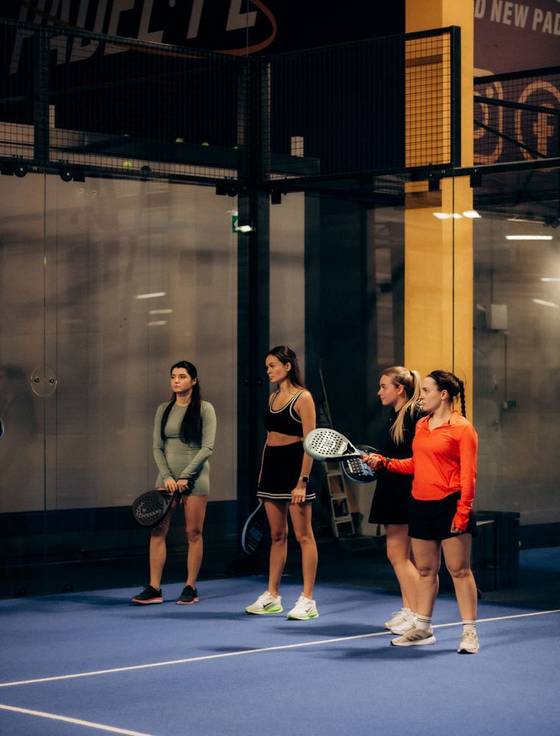 Four players on an indoor padel court