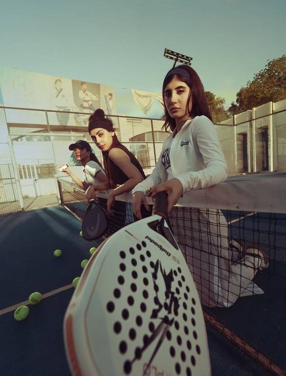 Padel players on an outdoor court at golden hour
